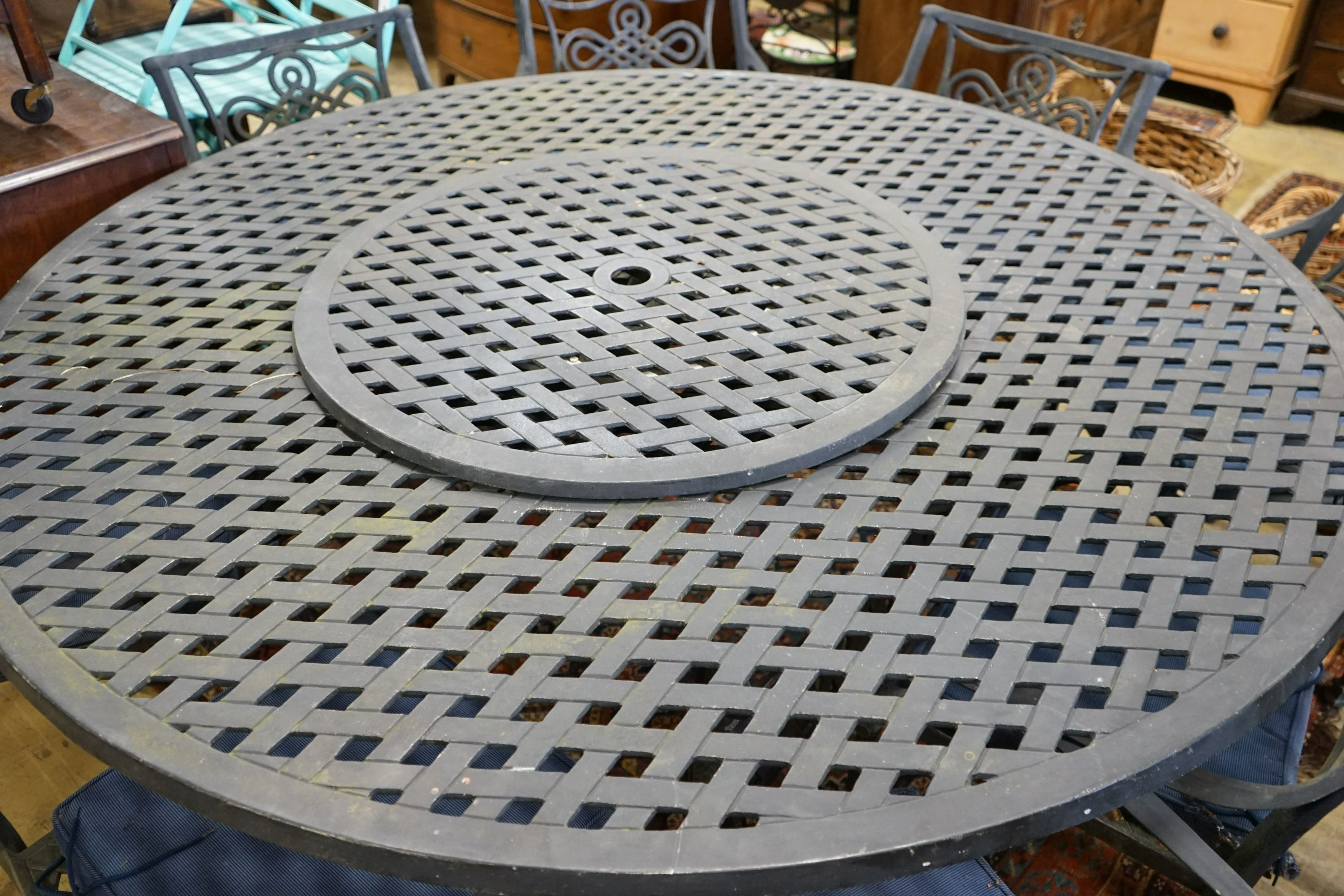 A circular painted aluminium garden table with 'lazy Susan', diameter 180cm, height 73cm together with ten aluminium elbow chairs with seat pads, (one base strut missing from table).
